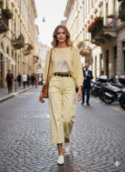 Woman in a yellow outfit walking down a city street.