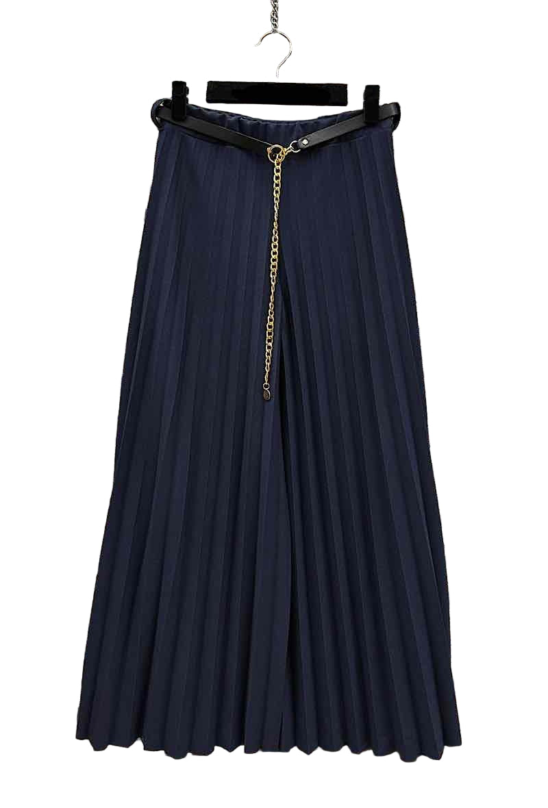 Navy blue pleated skirt with a gold zipper on a hanger against a stone wall background