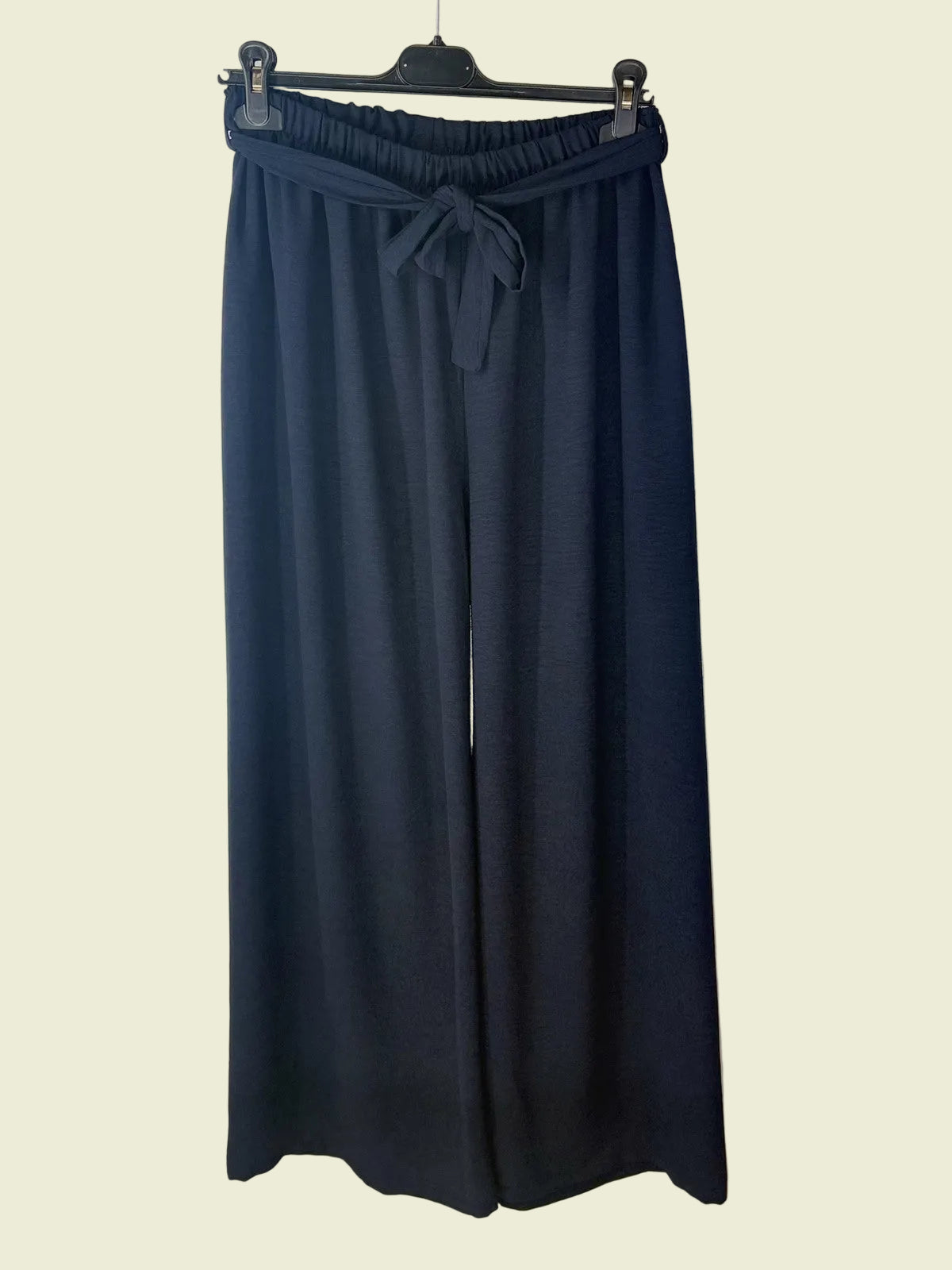 Navy blue wide-leg pants on a hanger 