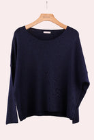 Navy blue sweater on a wooden hanger 