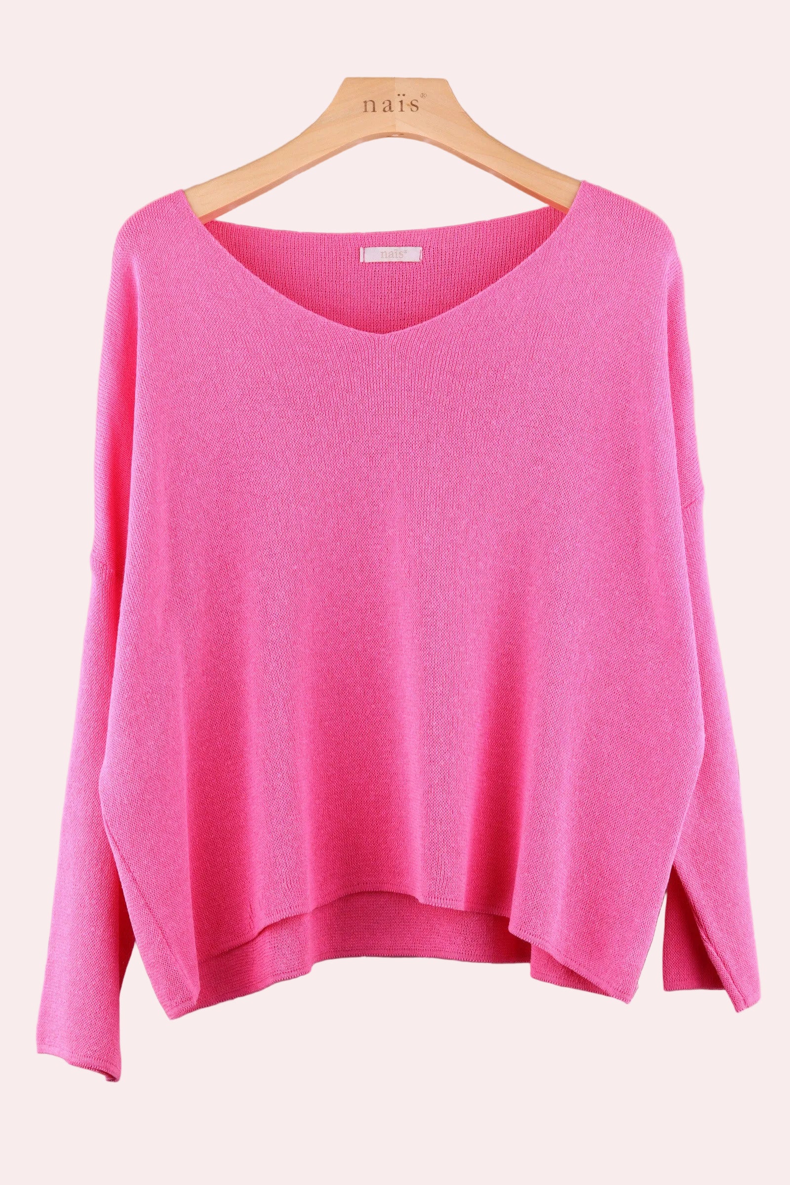 Pink sweater on a wooden hanger 