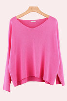 Pink sweater on a wooden hanger 