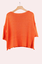 Orange sweater on a hanger 