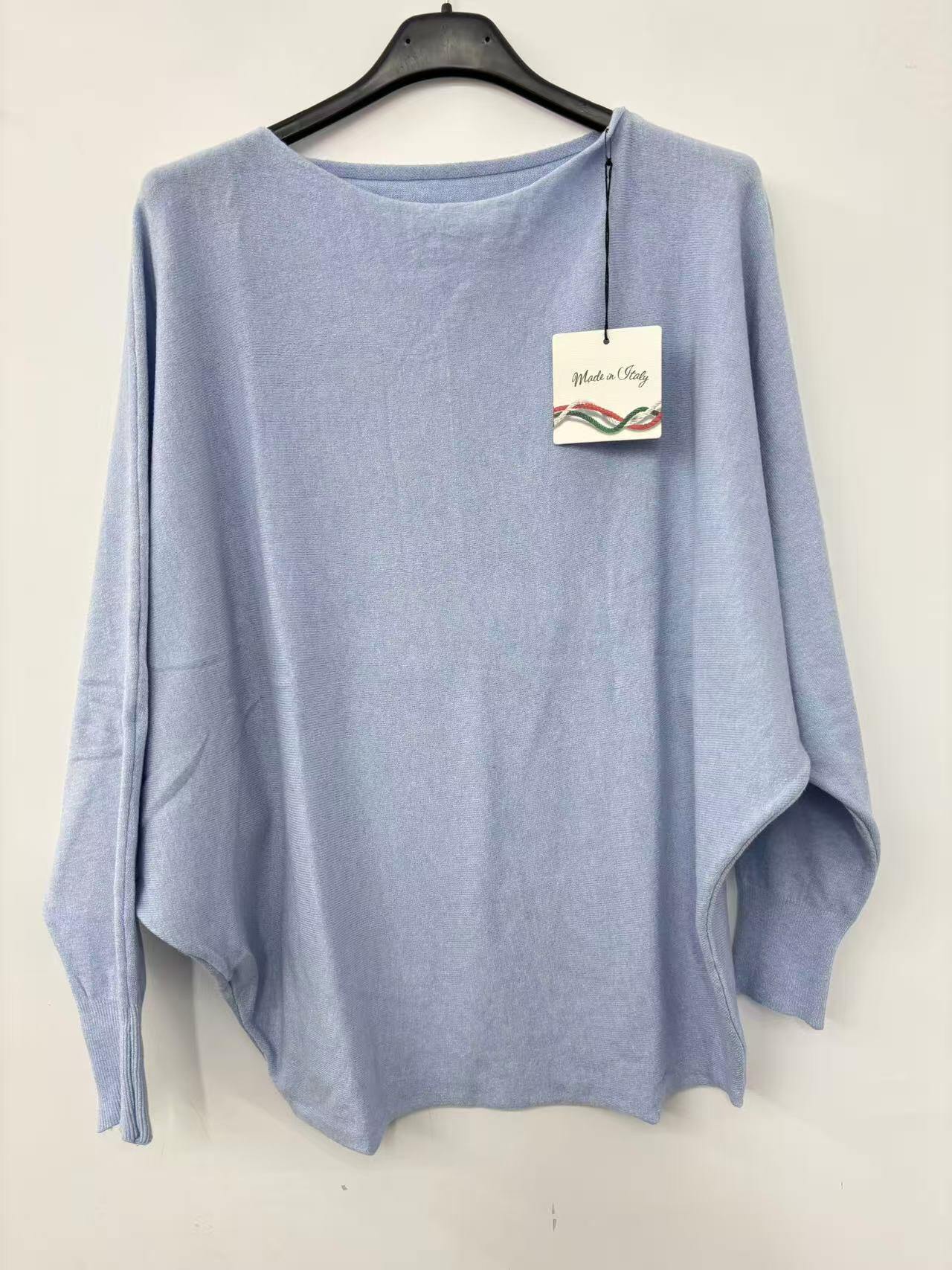 Blue sweater on a hanger with a tag against a white background