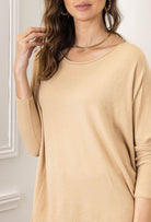 Beige sweater worn by a person against a neutral background
